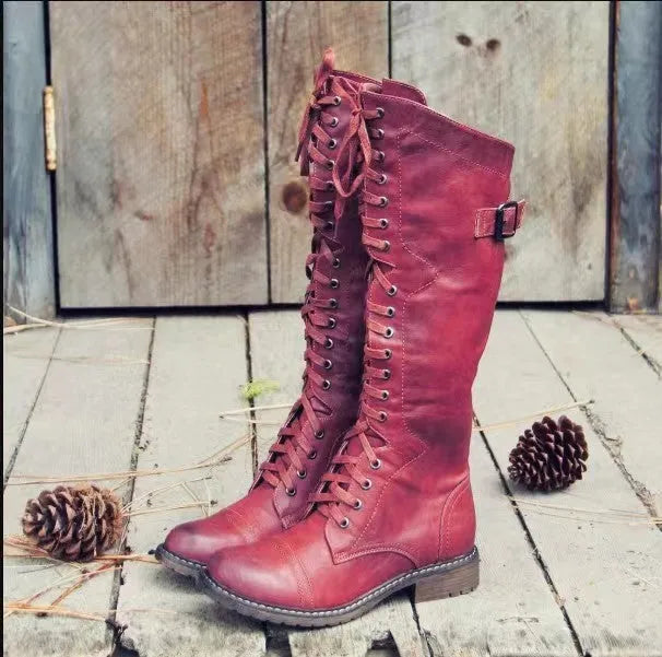 Women's black high leg boots with a round toe and low chunky heel on a plain background
