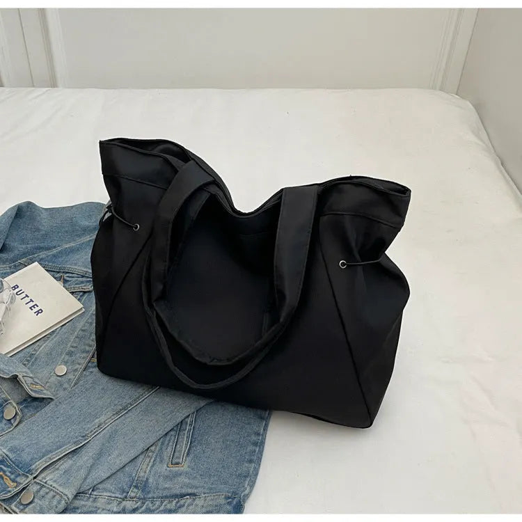 A foldable Oxford cloth commuter shoulder tote bag shown in one of five colours: black, brown, dark gray, light gray, or purple.