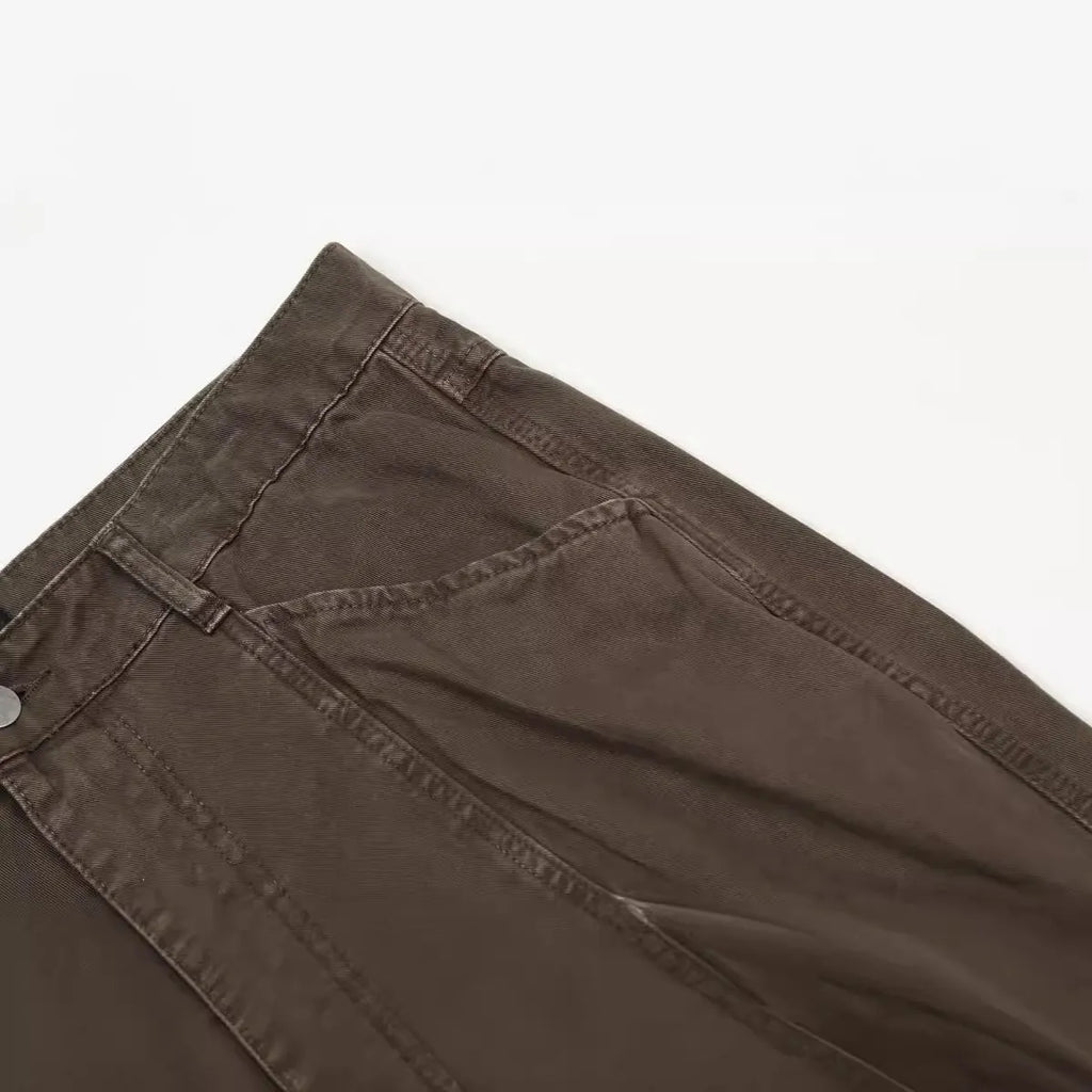 Men's loose straight-leg cotton trousers in brown, showing high waist and zipper fly.
