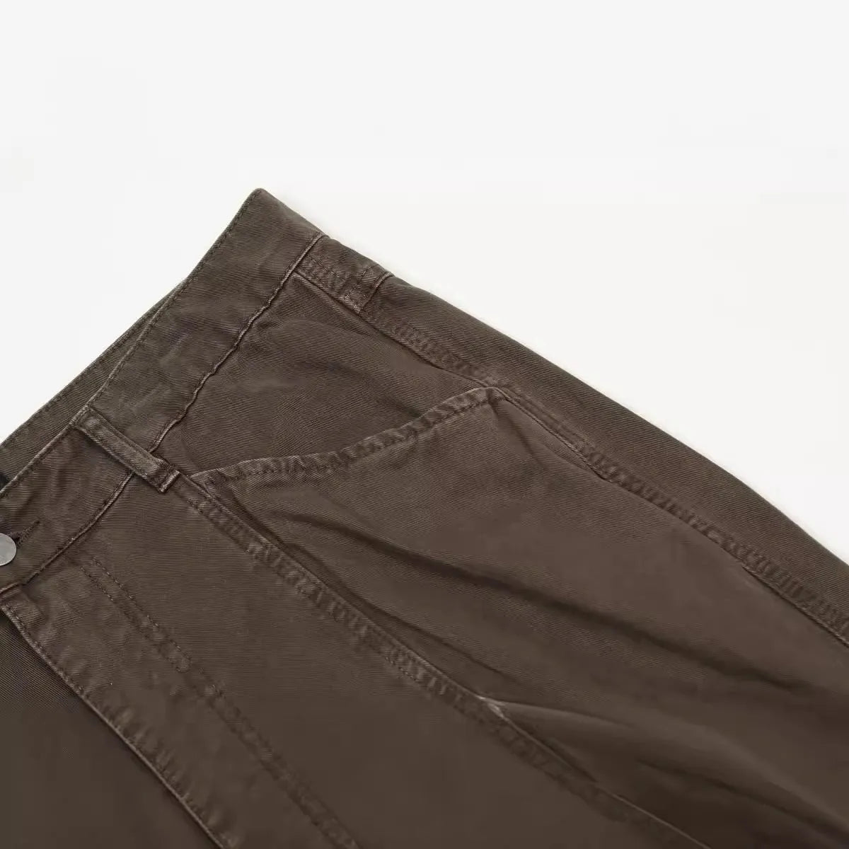 Men's loose straight-leg cotton trousers in brown, showing high waist and zipper fly.