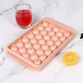 Blue silicone ice cube tray with lid showing 33 round cavities for large ice.