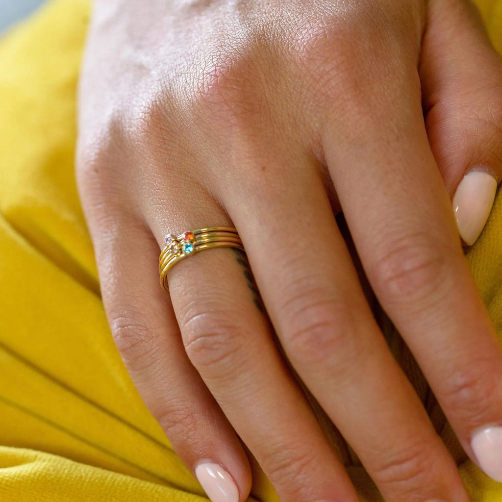 Geometric titanium steel ring with engraved December birthstone design on a finger.