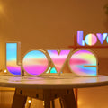 LED decorative light with rainbow-coloured LOVE word on plastic shade