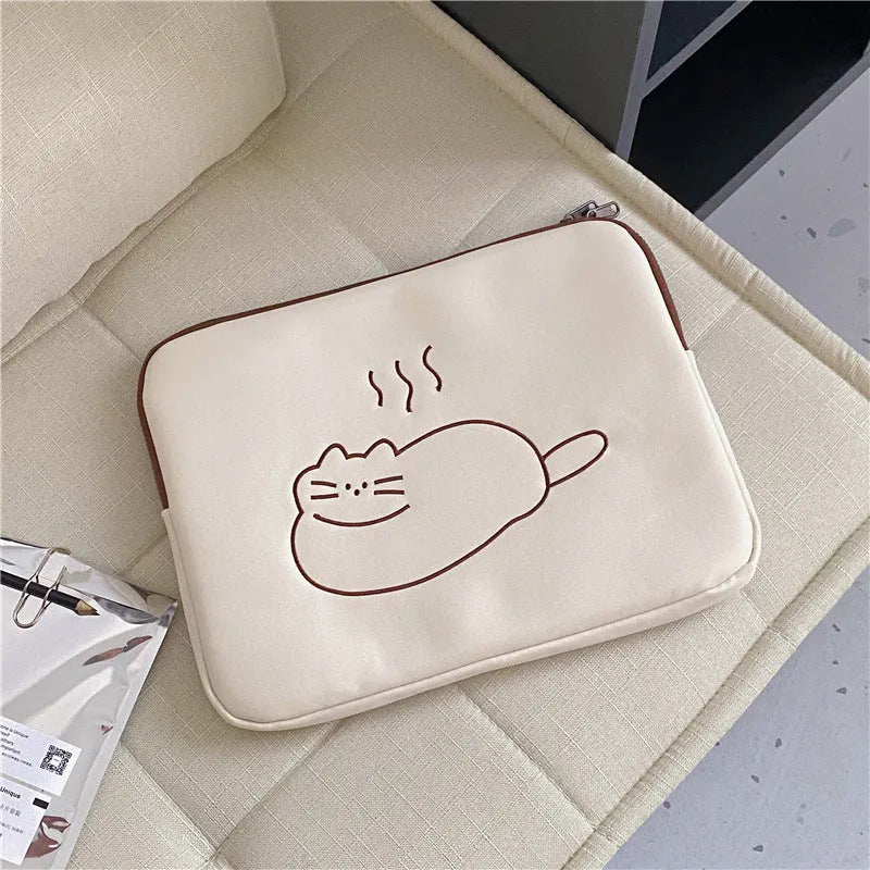 Embroidered fat cat design on a navy blue nylon laptop sleeve with a black zip
