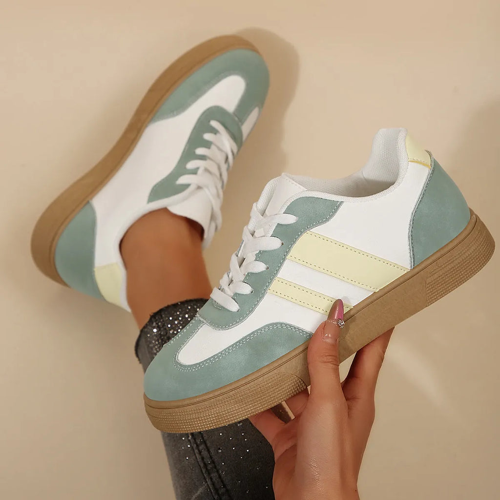 Green retro sports women's pumps with cross straps, leather stitching, round toe, and a low flat rubber sole.