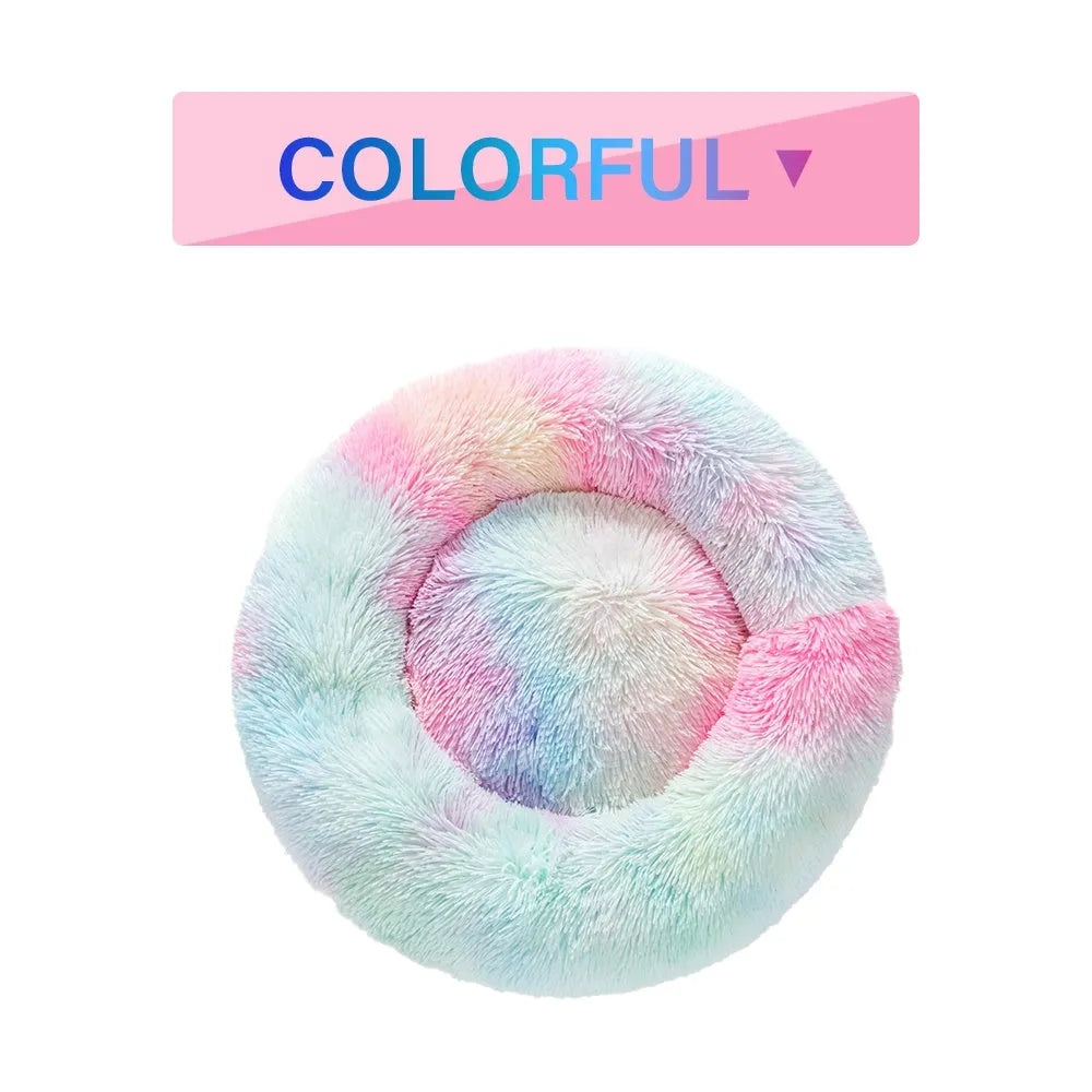 Fluffy donut-shaped dog bed in long plush material, shown in a light grey colour.