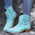 Blue women's cowboy boots with embroidery on the shaft and a low wedge heel.