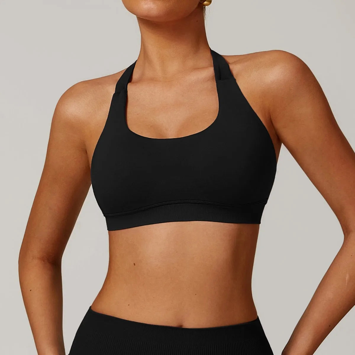 Women's black halter sports bra with medium support for yoga and workouts.