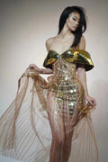 Gold strapless long dress with sequined tulle skirt and high side split, worn as formal evening wear.