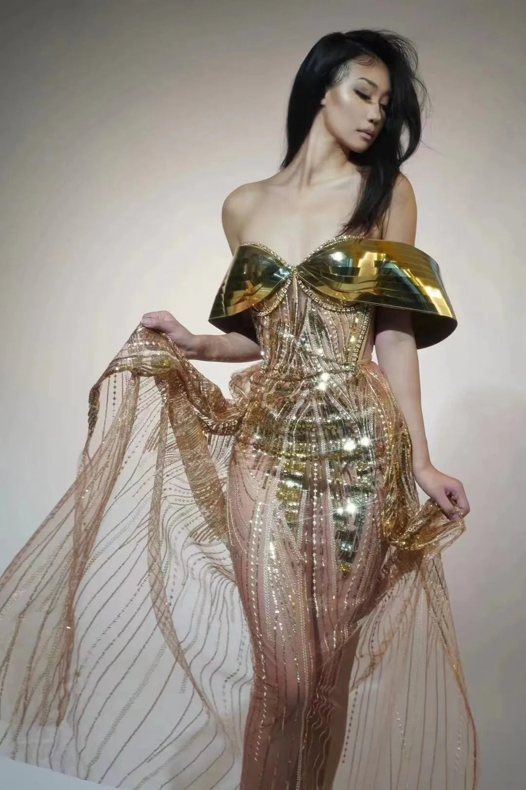 Gold strapless long dress with sequined tulle skirt and high side split, worn as formal evening wear.