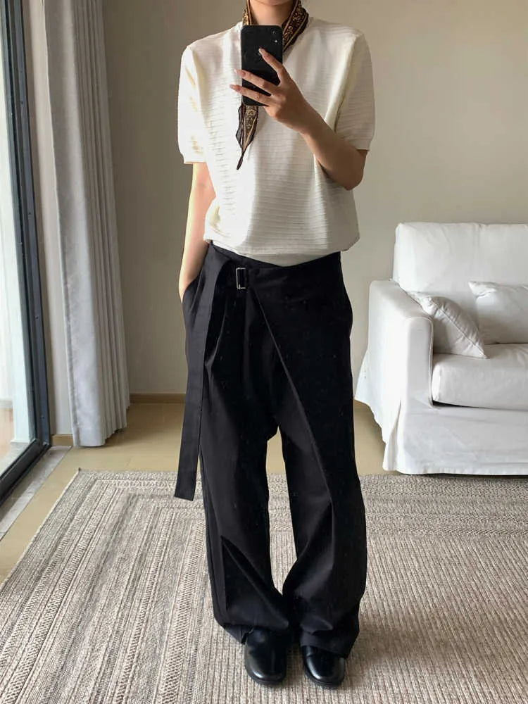 Black straight-leg Tencel cotton trousers with a single pleat and adjustable waistband on a hanger.
