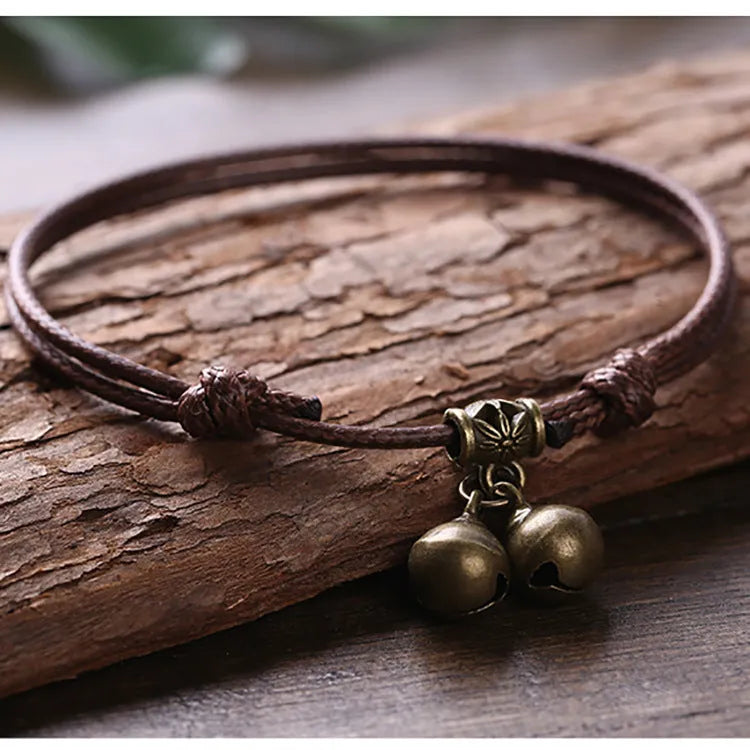 Adjustable nylon dog collar with brass bell, shown in black rope colour on a size chart.