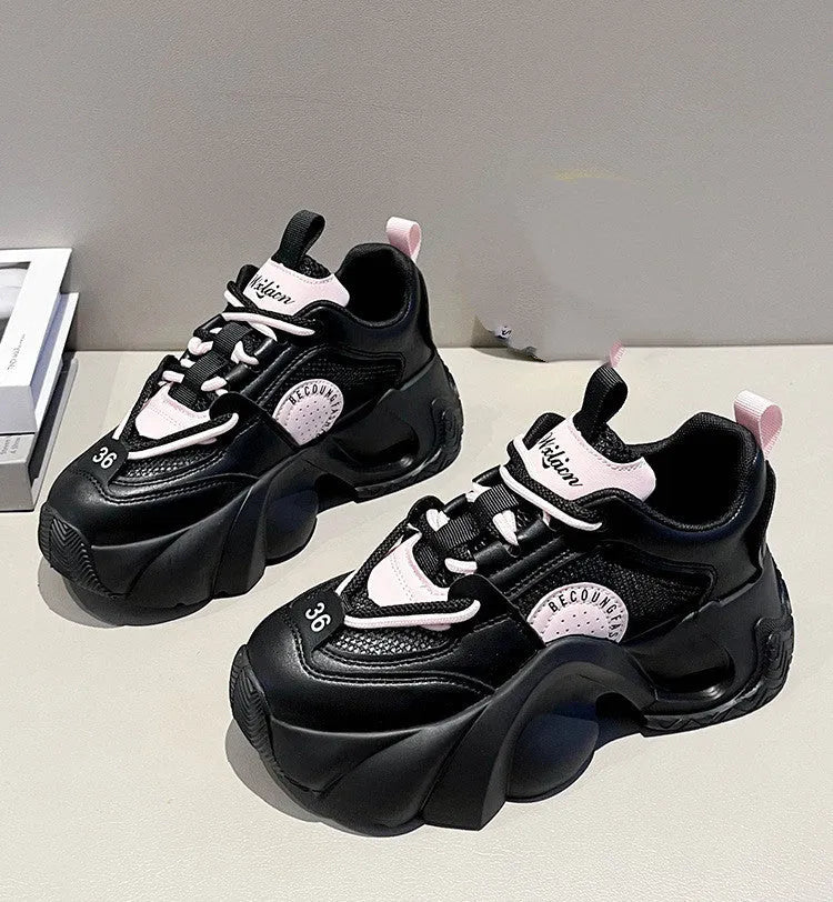 Women's pink casual sneakers with a cross strap, thick rubber sole, and mesh lining on a white background.
