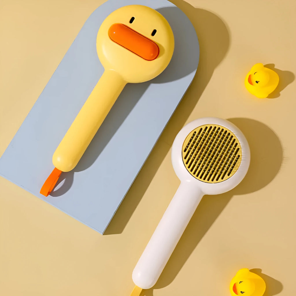 Small yellow duck-shaped pet grooming comb with needle teeth for cats and dogs