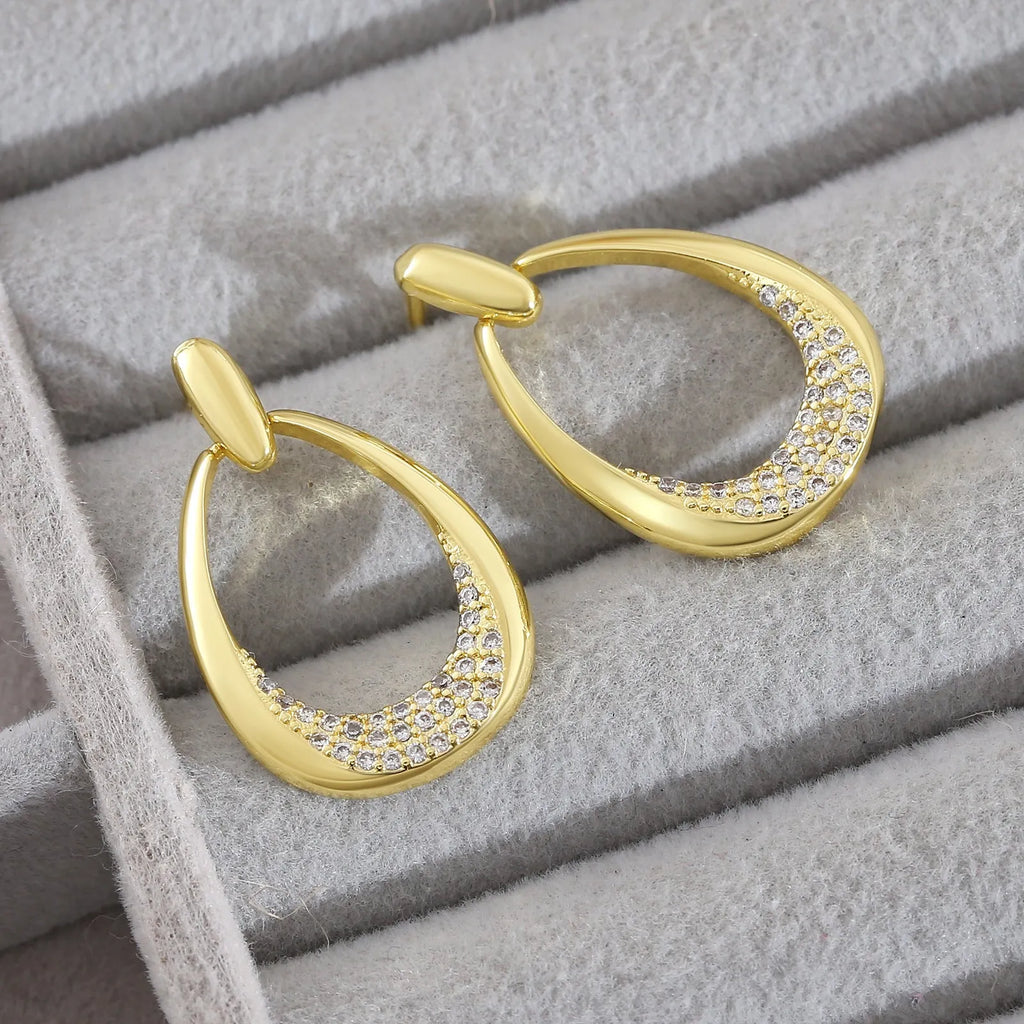 Women's geometric drop earrings with zircon details and yellow gold electroplated finish measuring 2.6 by 1.7 cm