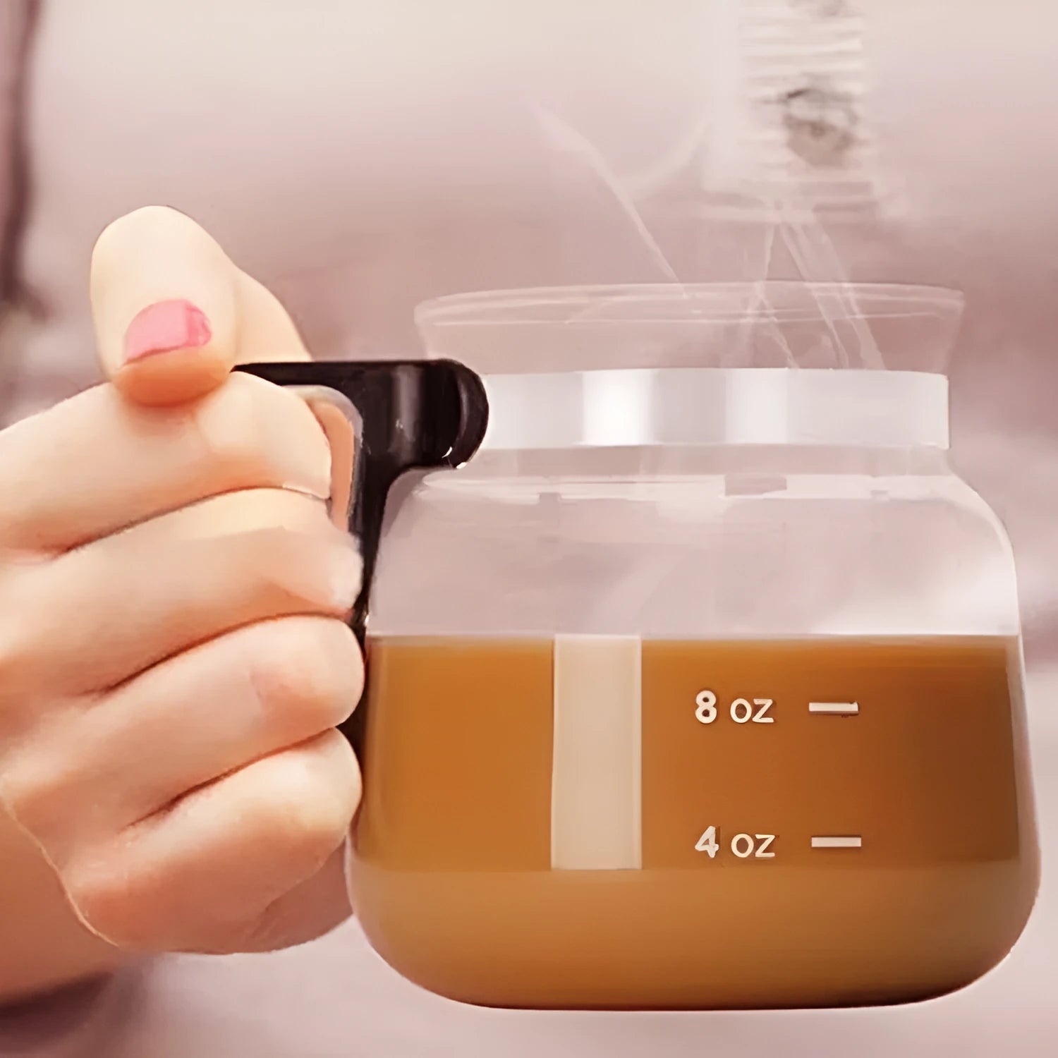 Transparent borosilicate glass pour-over coffee maker with a black silicone cover on a kitchen counter.