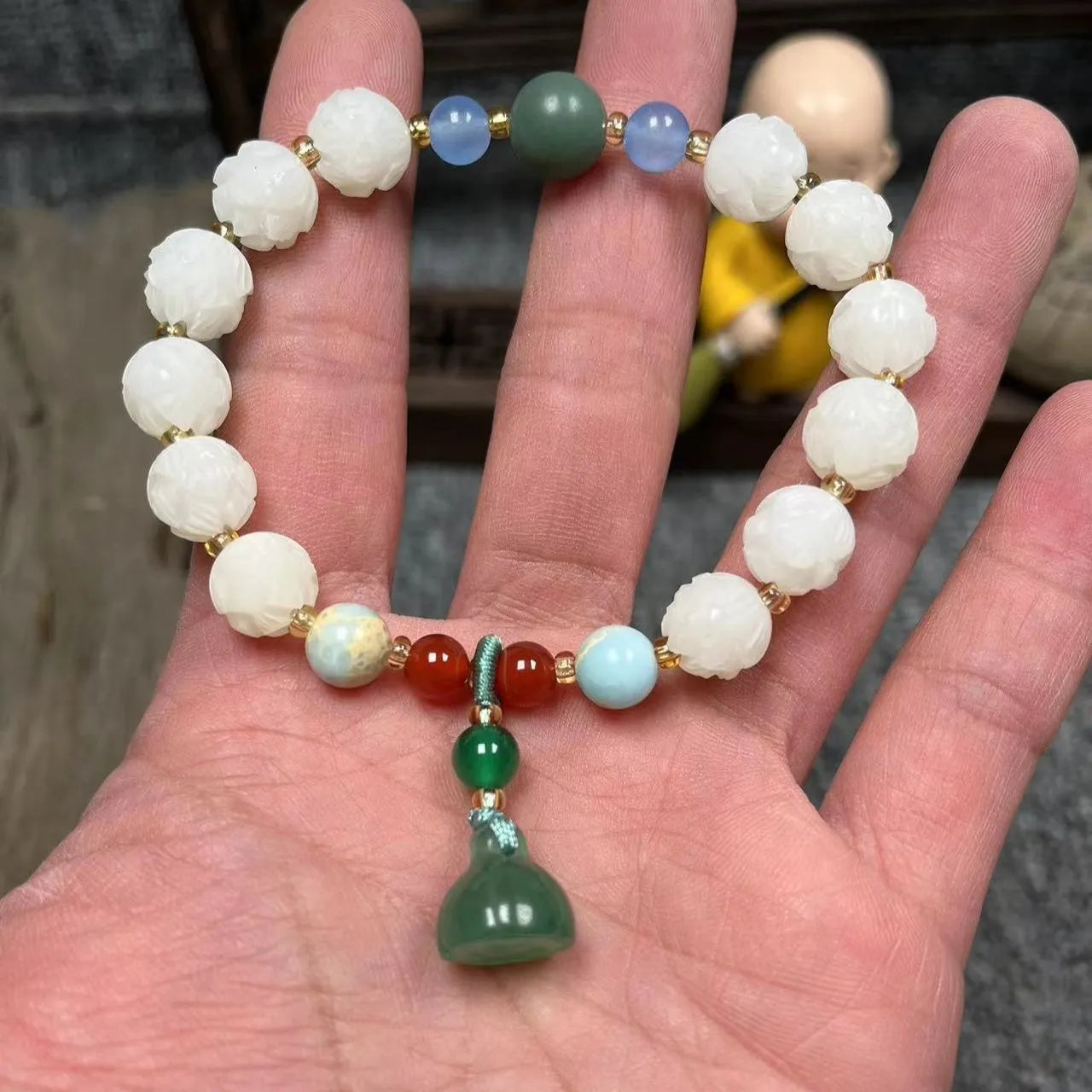Carved Bodhi root bracelet with white jade, lotus, and pumpkin beads in various sizes.