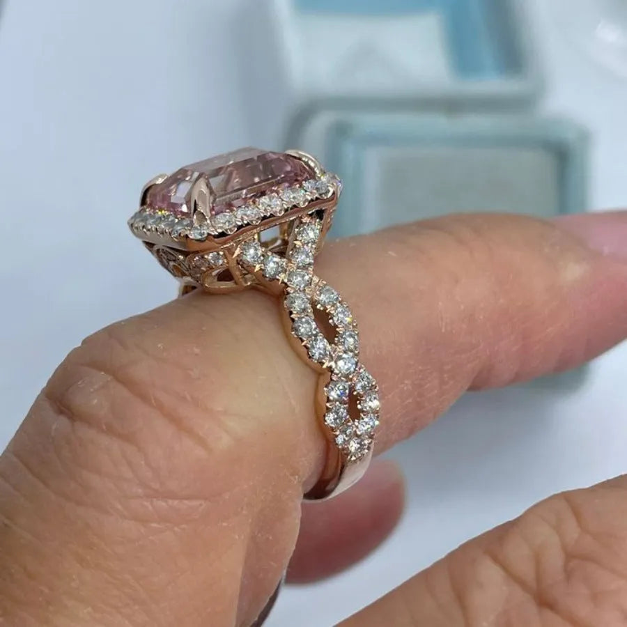 A geometric-shaped rose gold alloy ring on a plain background.