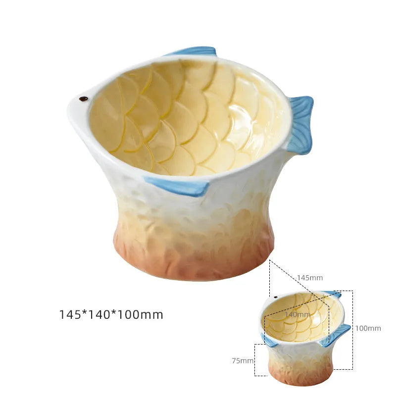 Blue fish-shaped ceramic cat feeder bowl with shallow tilt angle and non-slip base on a wooden surface.