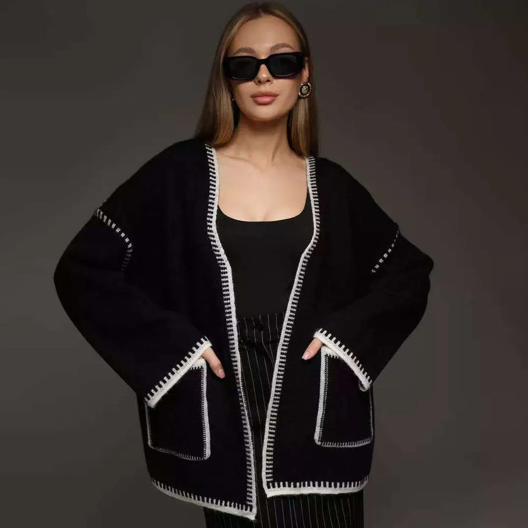 A loose, mid-length knitted cardigan with a front lace-up detail, shown in a camel colour.