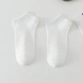 A pair of solid colour low-cut polyester boat socks for men, shown in one of six available colours.