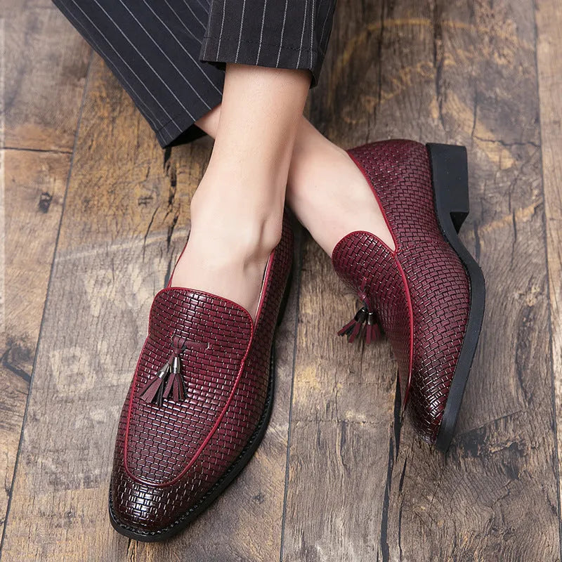 Men's black pointed-toe slip on shoes with a tassel detail on the low-top PU upper.