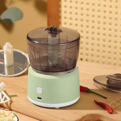White and light green mini electric meat grinder with stainless steel blade on kitchen counter