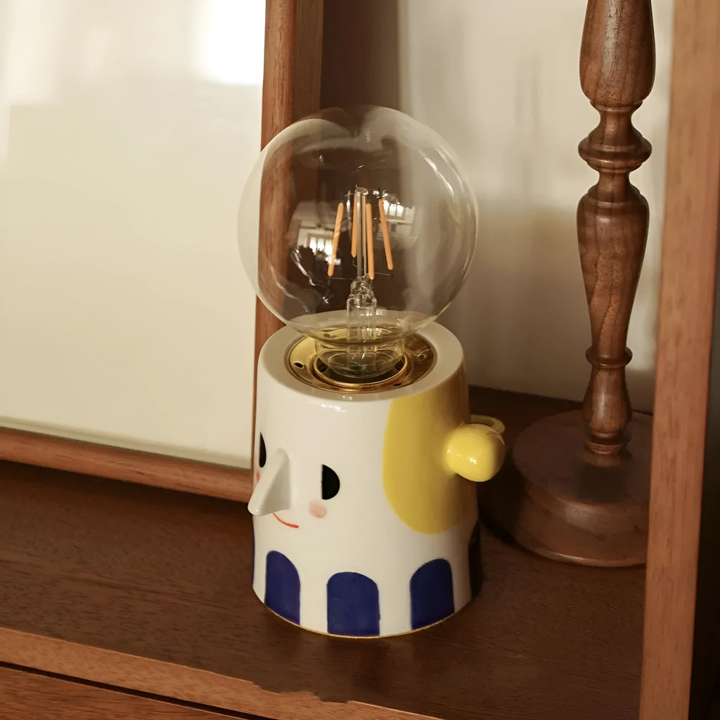 Handmade ceramic table lamp with a spherical ball headlight shade on a ceramic base.