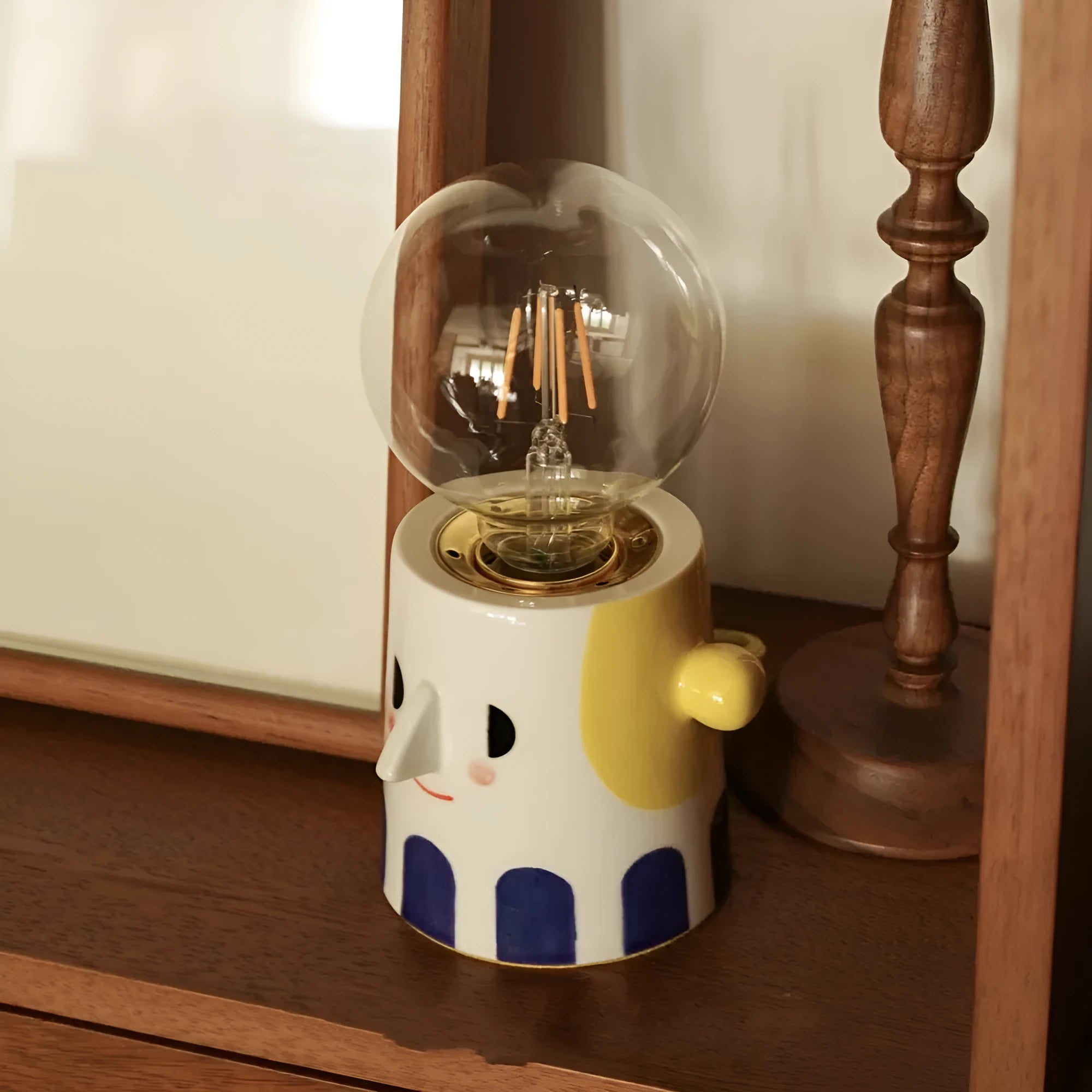 Handmade ceramic table lamp with a spherical ball headlight shade on a ceramic base.