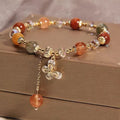 Colourful hair crystal bracelet with cat's paw, flower, butterfly, and coin purse charms on an adjustable band.