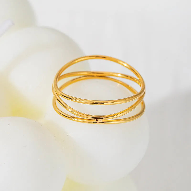 Gold-coloured geometric line ring with three-layer coil design on titanium steel band