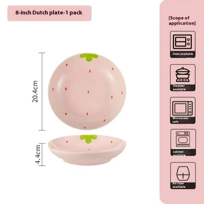 Cute strawberry pattern porcelain dinnerware set showing bowl, plate, and twist spoon on a table.