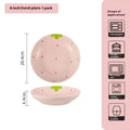 Cute strawberry pattern porcelain dinnerware set showing bowl, plate, and twist spoon on a table.