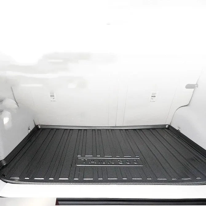 Black carbon fibre pattern TPE rubber boot liner mat for a car trunk.