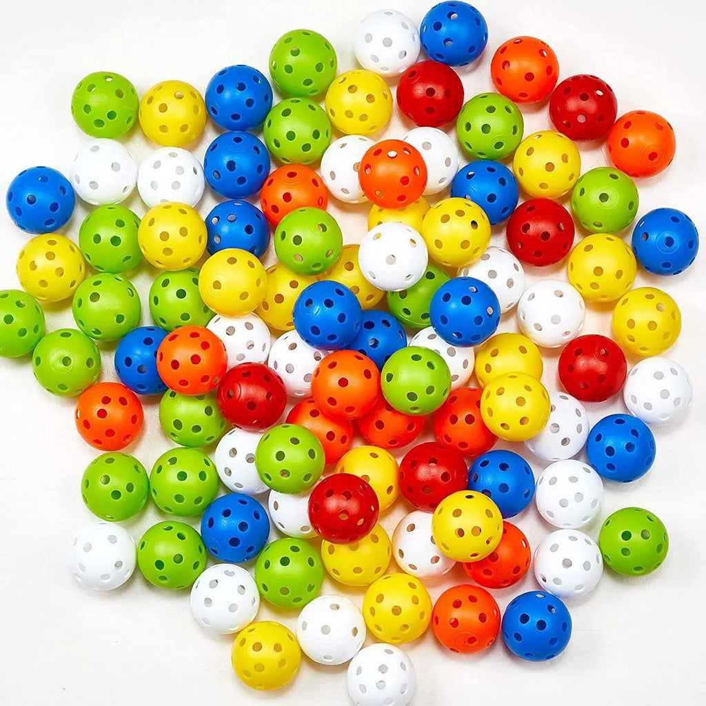 Six coloured 42mm golf practice balls in red, orange, blue, green, white and yellow arranged on putting surface