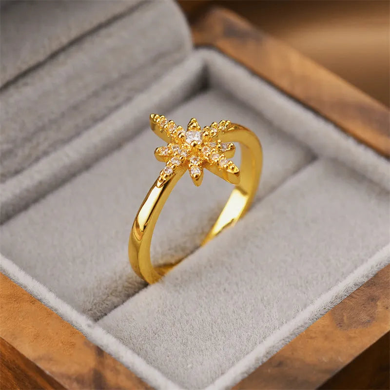 Gold geometric open fashion ring for women on a plain background.