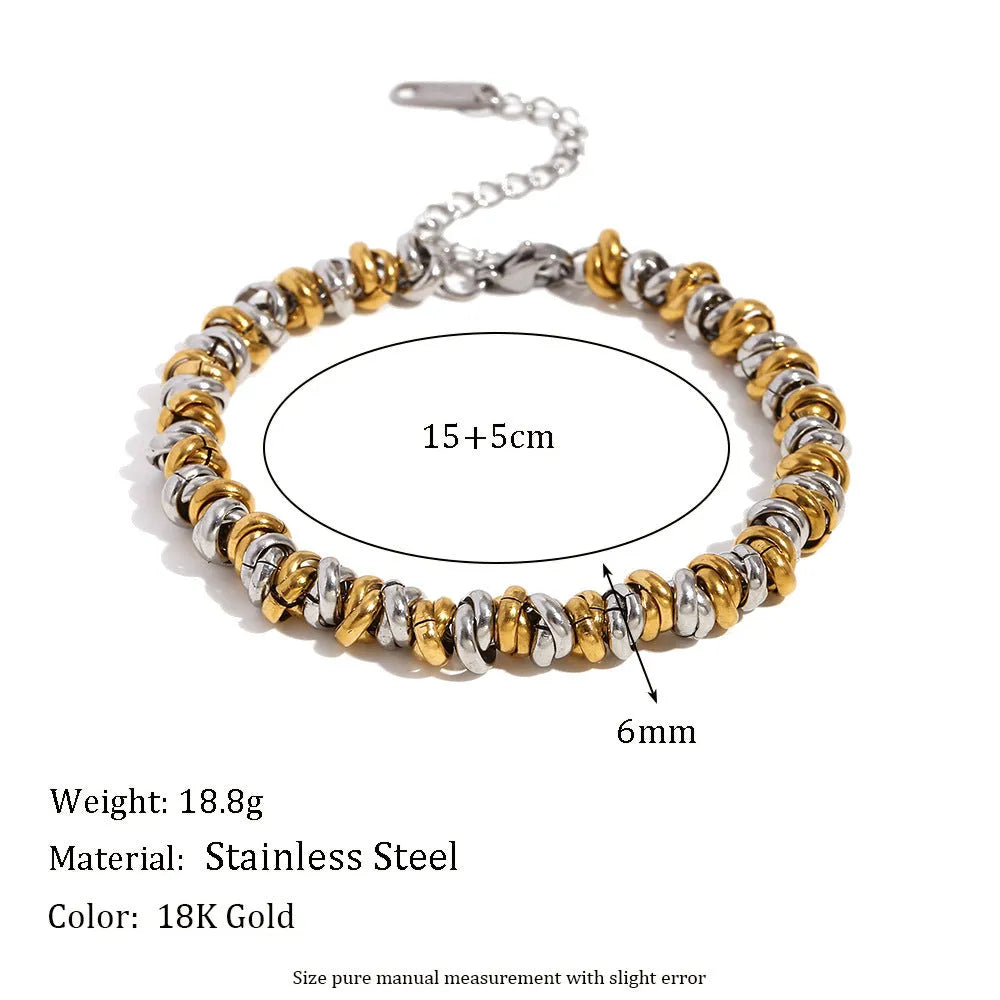Gold geometric stainless steel earrings, bracelet, and necklace set on a white background.