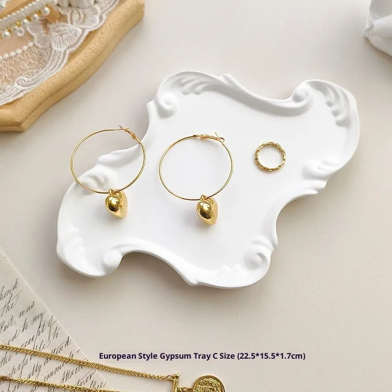 European Baroque style gypsum jewellery display plate with rings and earrings on a dressing table