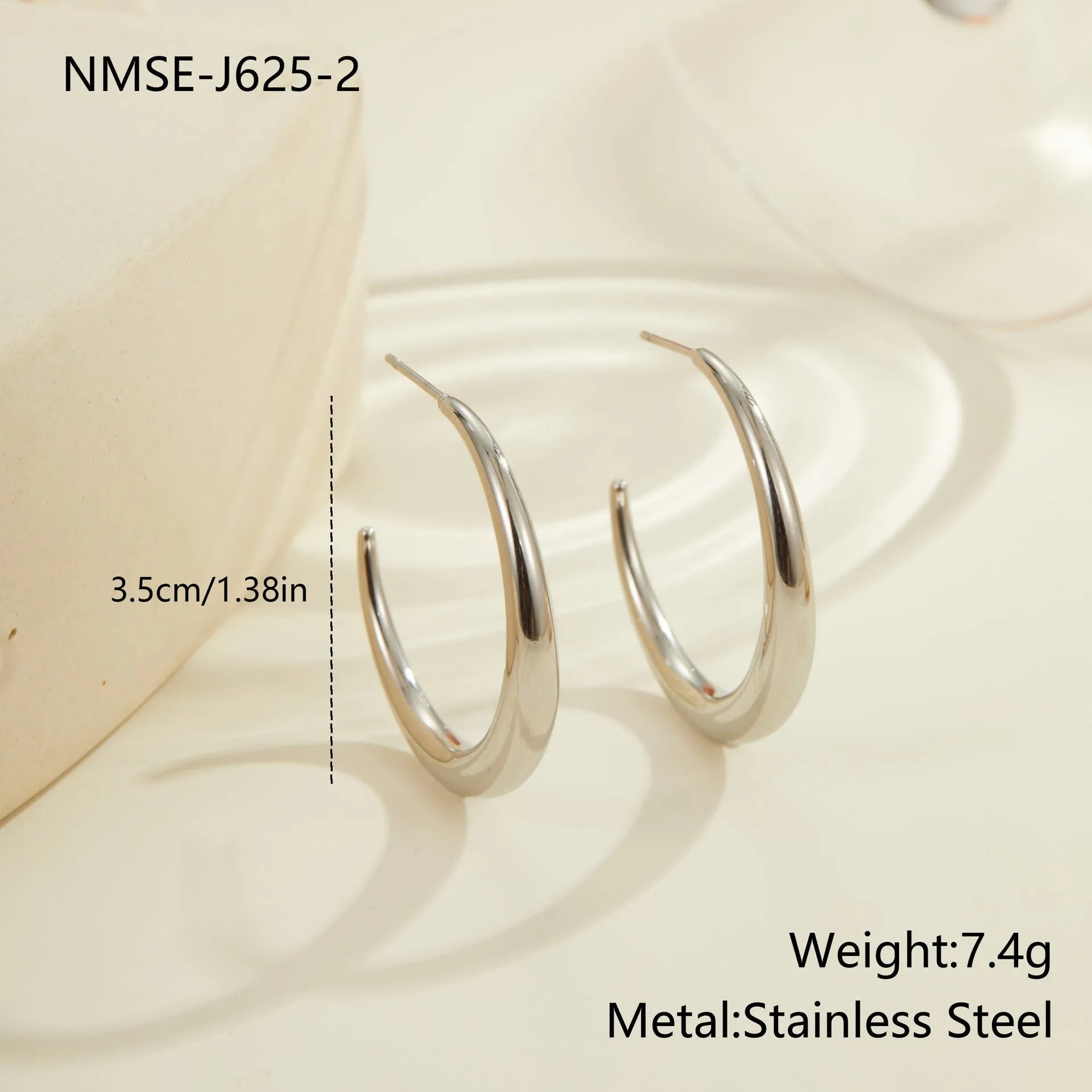 A pair of simple round titanium stainless steel hoop earrings shown in both gold and steel finishes.