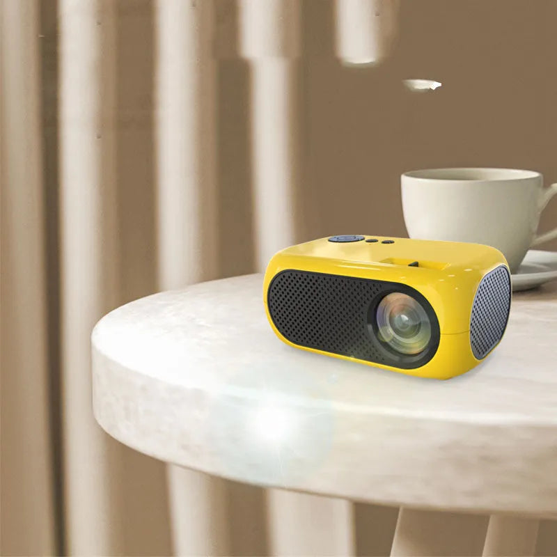 M24 micro mini portable LED projector in gold or white colour on a grey background