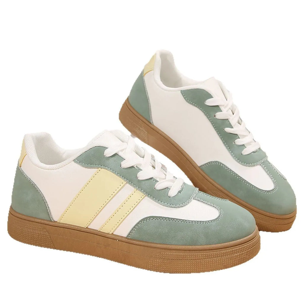 Green retro sports women's pumps with cross straps, leather stitching, round toe, and a low flat rubber sole.