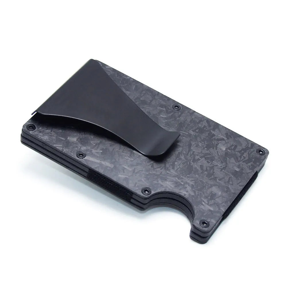 Slim black carbon fibre card holder wallet with geometric design on a table.