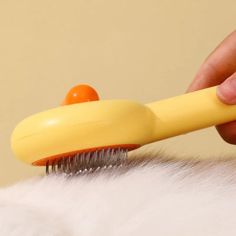 Small yellow duck-shaped pet grooming comb with needle teeth for cats and dogs