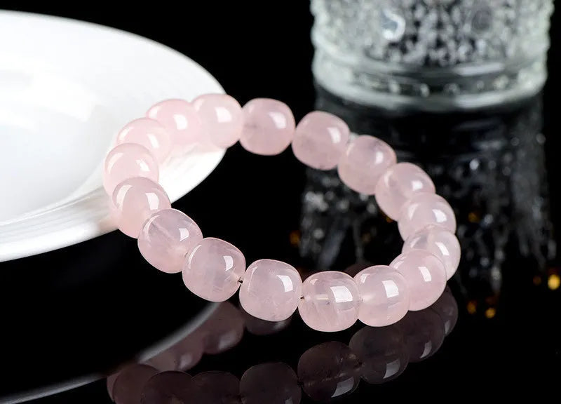 Pink natural bamboo crystal bracelet with 11-12mm geometric barrel beads on a wrist.