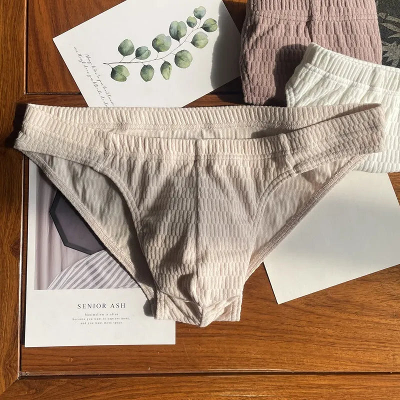 Men's solid colour cotton triangle briefs in apricot, shown from the front on a mid-waist fit model.