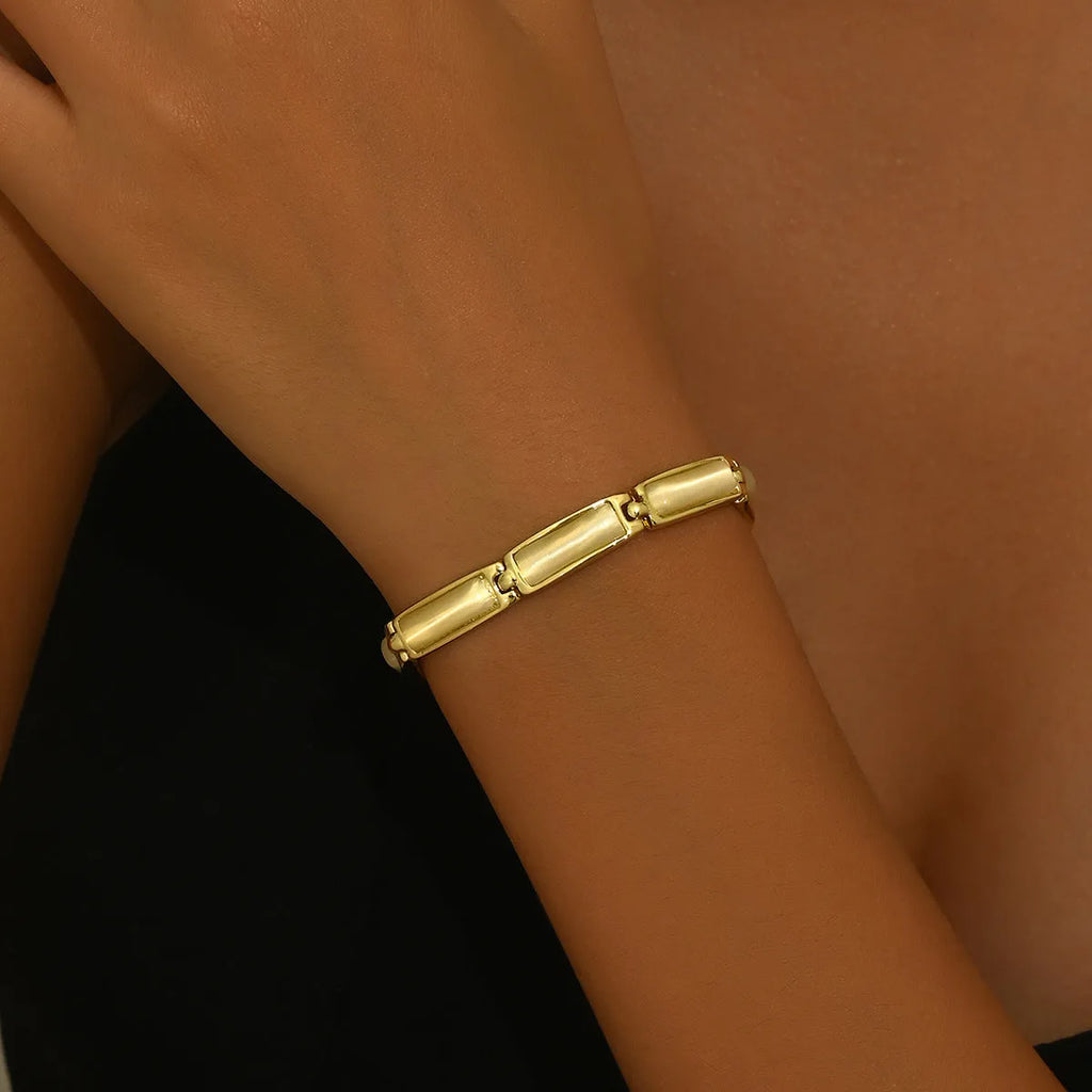 Women's geometric rose gold opal bracelet with quadrilateral shape and gemstone inlay on a plain background