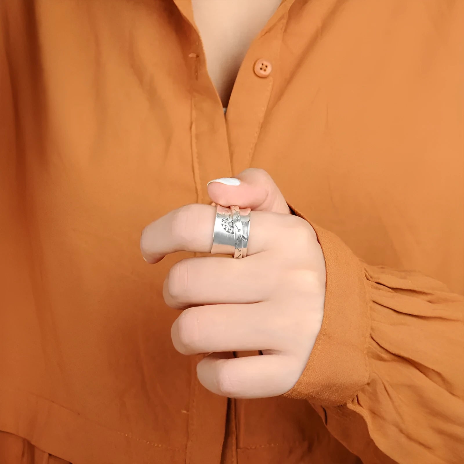 Silver rotatable flower ring showing adjustable floral element on finger