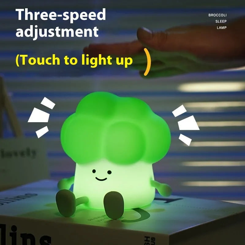 Cartoon eggplant-shaped small night lamp with soft yellow glow, shown next to a broccoli design variant.