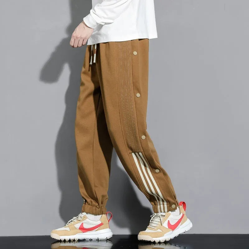 Man wearing loose grey sweatpants with ankle ties and a high waist.