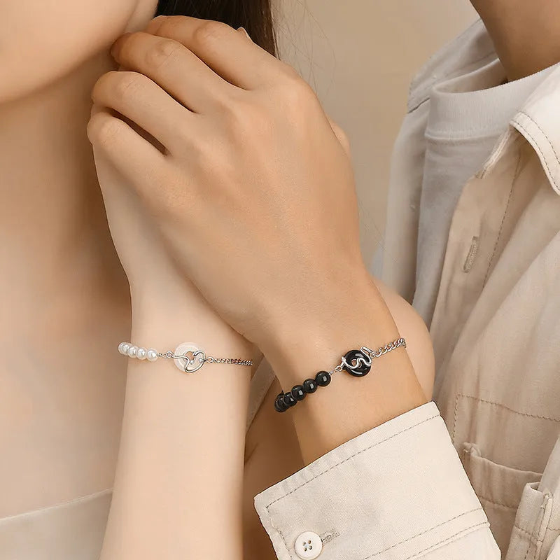 925 sterling silver bracelet with snake charm, obsidian pearl, and safe buckle closure on a wrist.